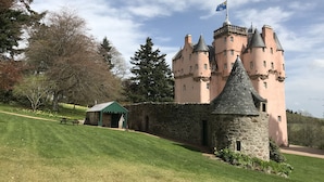 A castle with multiple towers, a stone wall, and a small pavilion. - South Mains Cottage - Craigievar Castle (Alford)