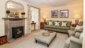 A cozy living room with a fireplace, a sofa set, and a chandelier. - South Mains Cottage - Craigievar Castle (Alford)