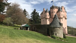 A castle with multiple towers, a stone wall, and a small pavilion.
