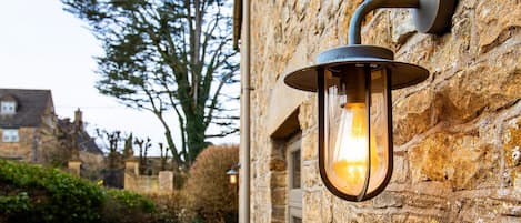 A stone wall with a mounted lantern-style light fixture.