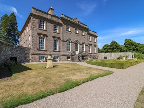 A large, historic stone building with multiple windows and a formal garden. - North Stables - House Of Dun (Montrose)