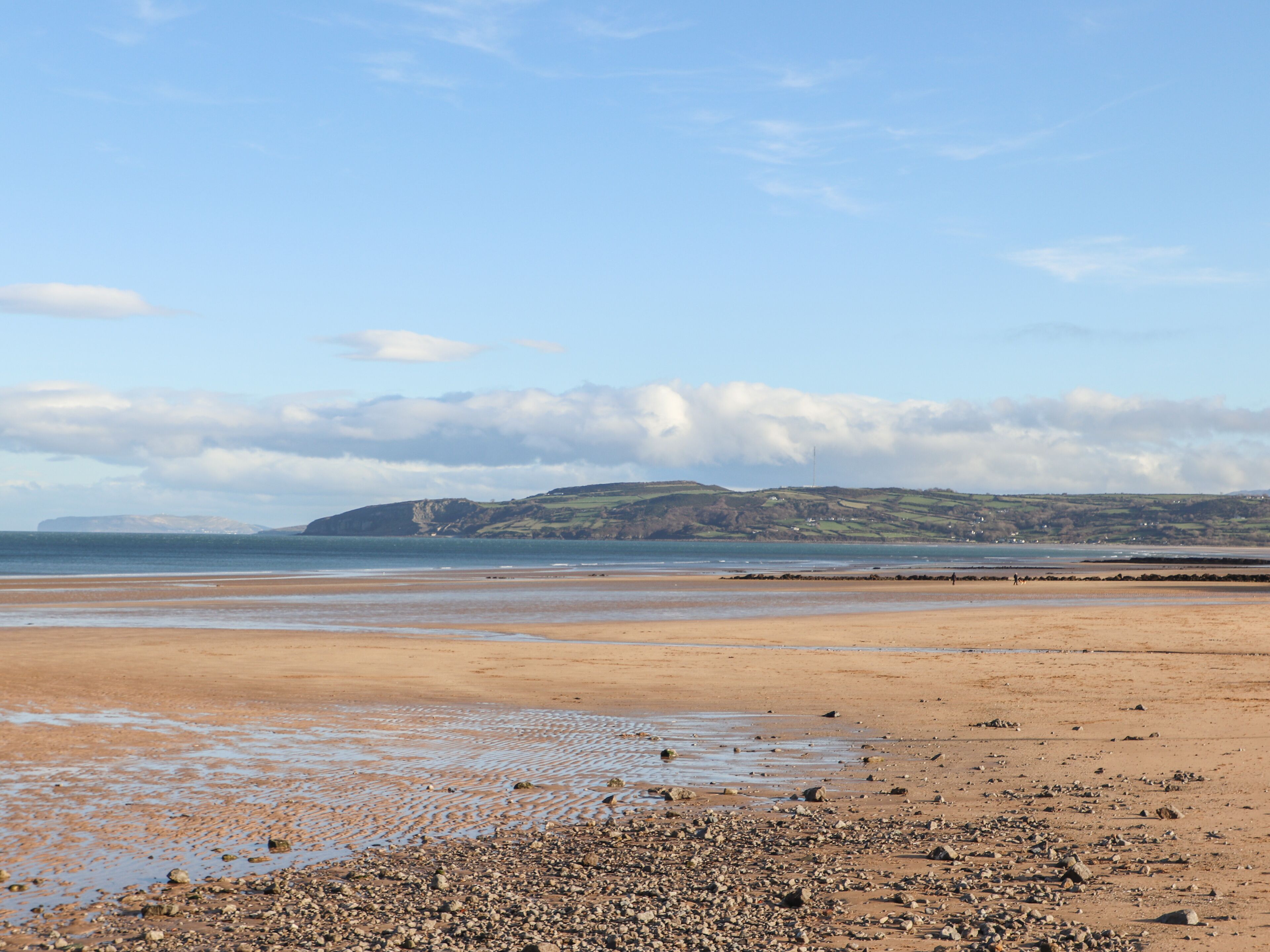 A beach with pebbles and a clear sky.