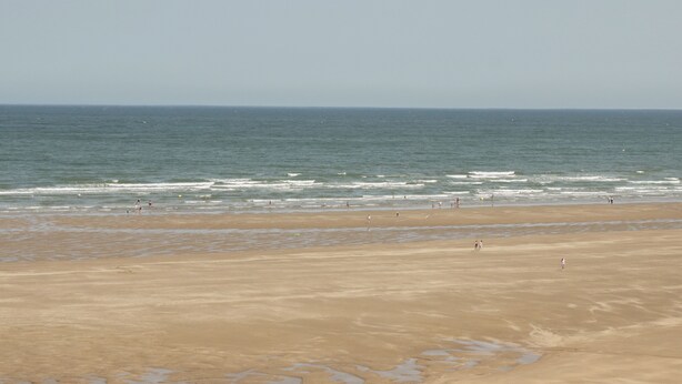 A wide sandy beach with gentle waves and a clear sky. - 4 Parc Delfryn (Brynteg)