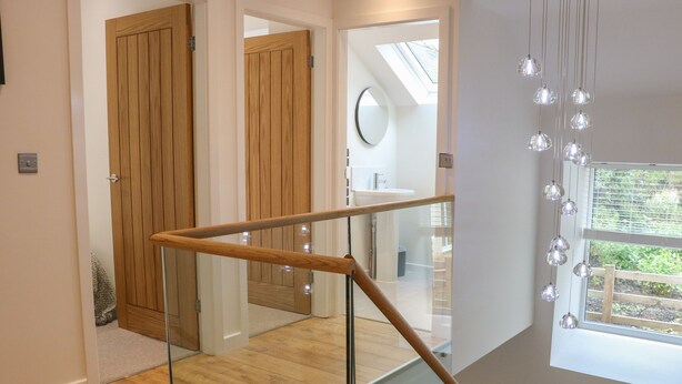 Un escalier moderne avec des rampes en verre et des marches en bois.