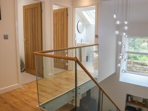 A modern staircase with glass railings and wooden steps. - Fig Cottage (Kirkby Stephen)