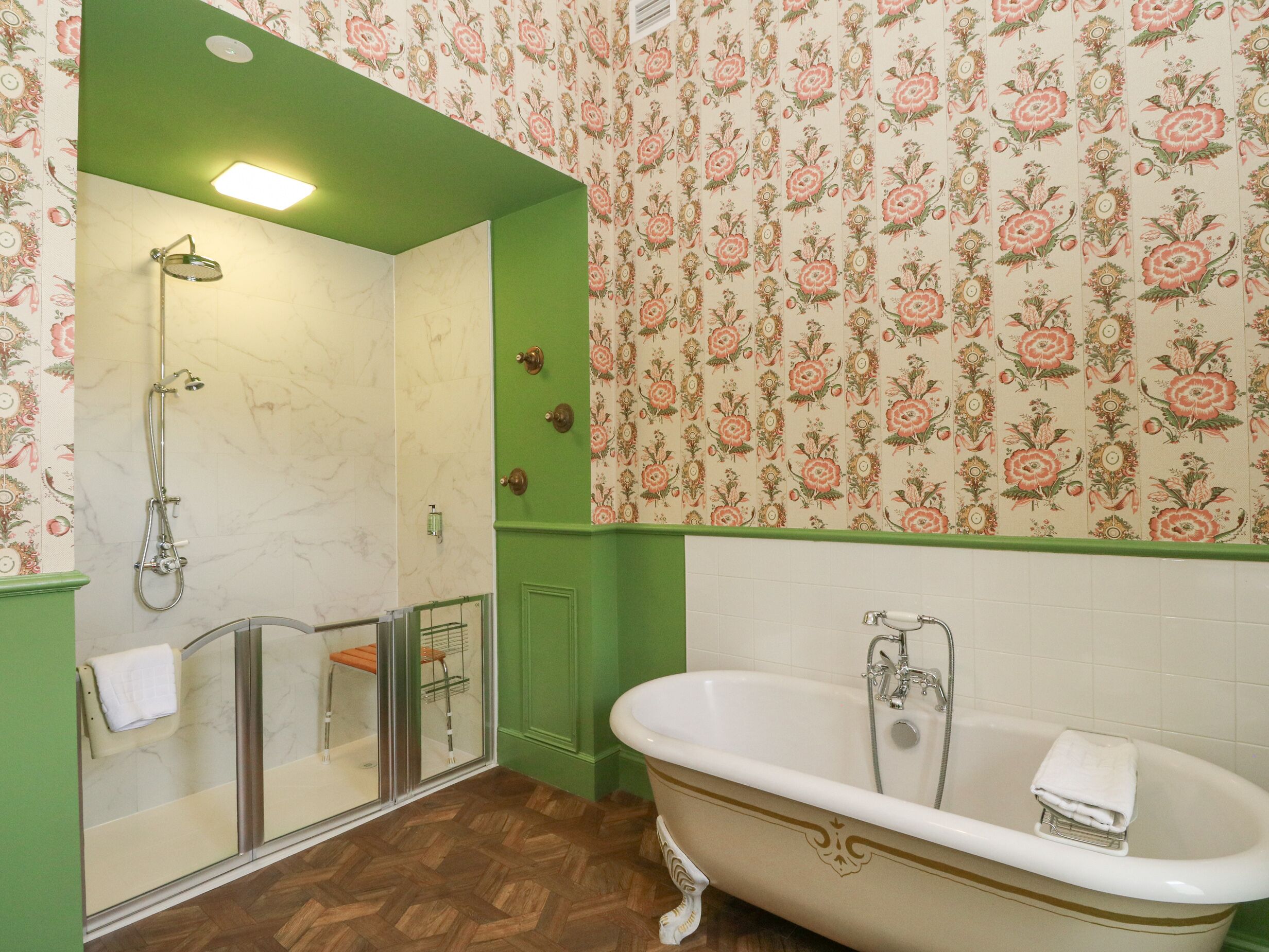 A bathroom with a shower, a bathtub, and a glass-enclosed shower area.