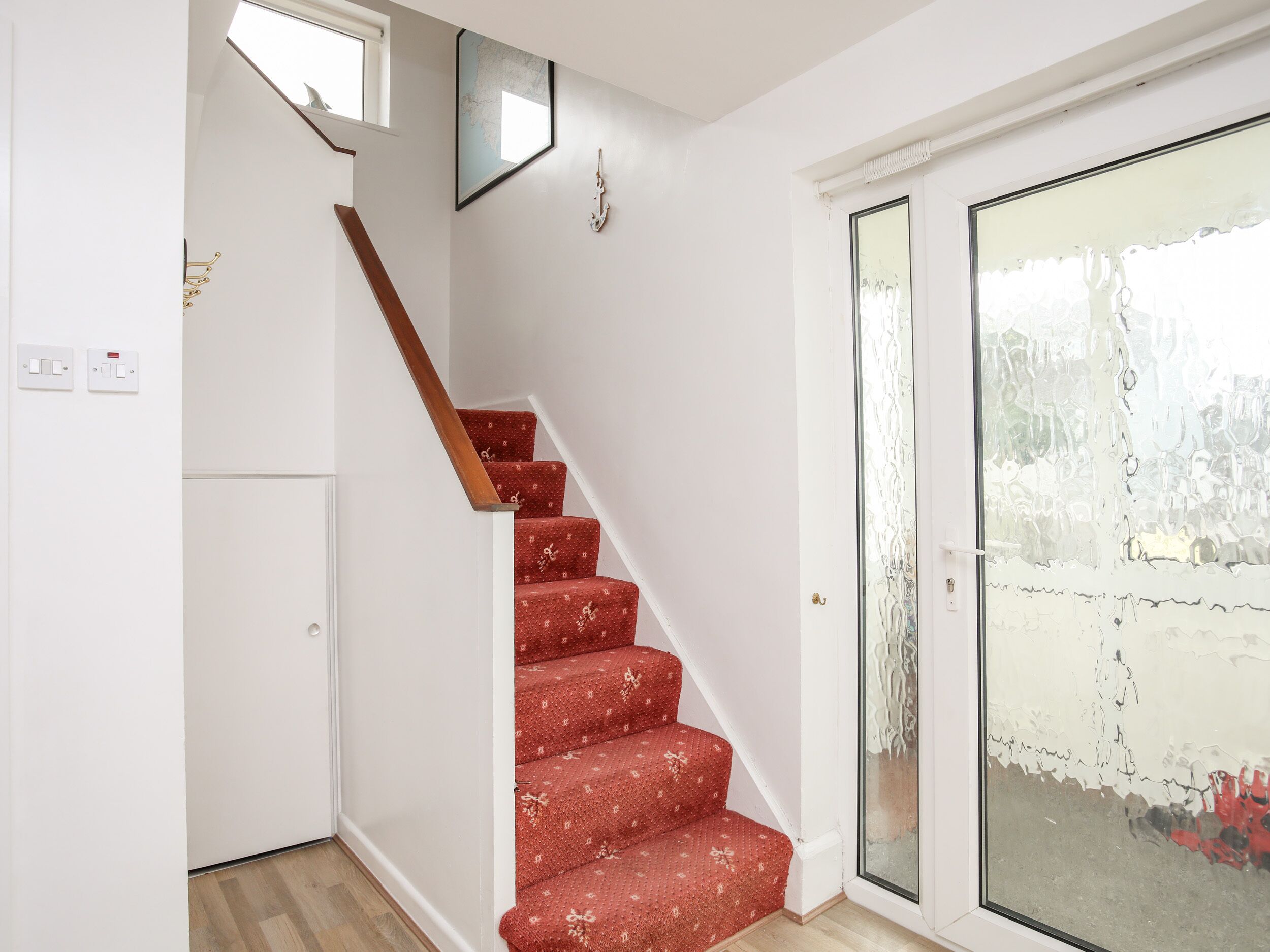 Eine Treppe mit roten Teppichstufen, die zu einer Empore führt.