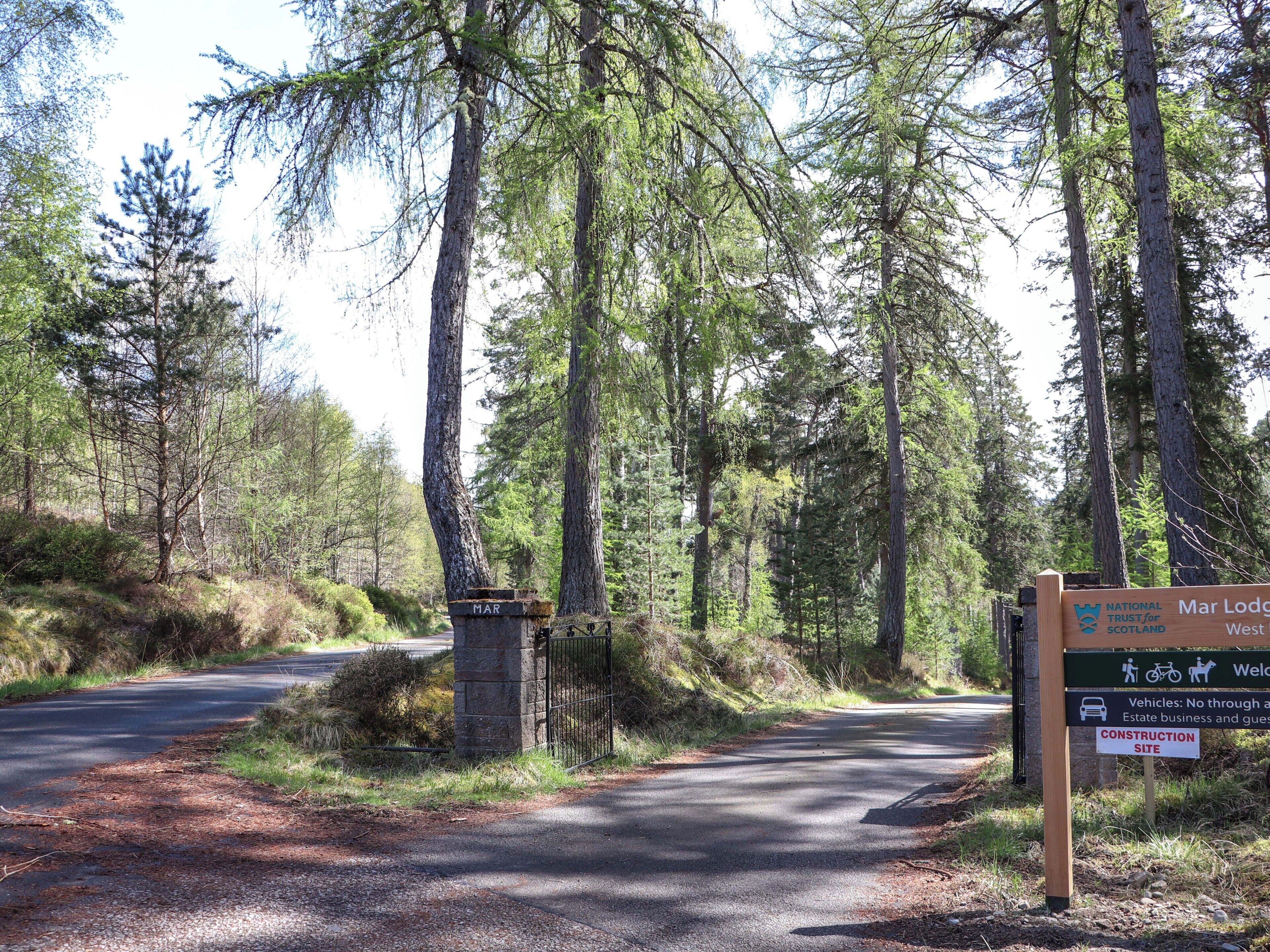 A forested area with a sign indicating Mar Lodge and a construction site.