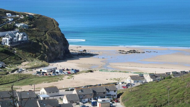 A coastal town with houses on a hillside overlooking a sandy beach and the sea. - Gecko Beach (Truro)