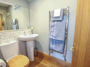 Une salle de bain équipée de toilettes, d’un lavabo et d’une douche.