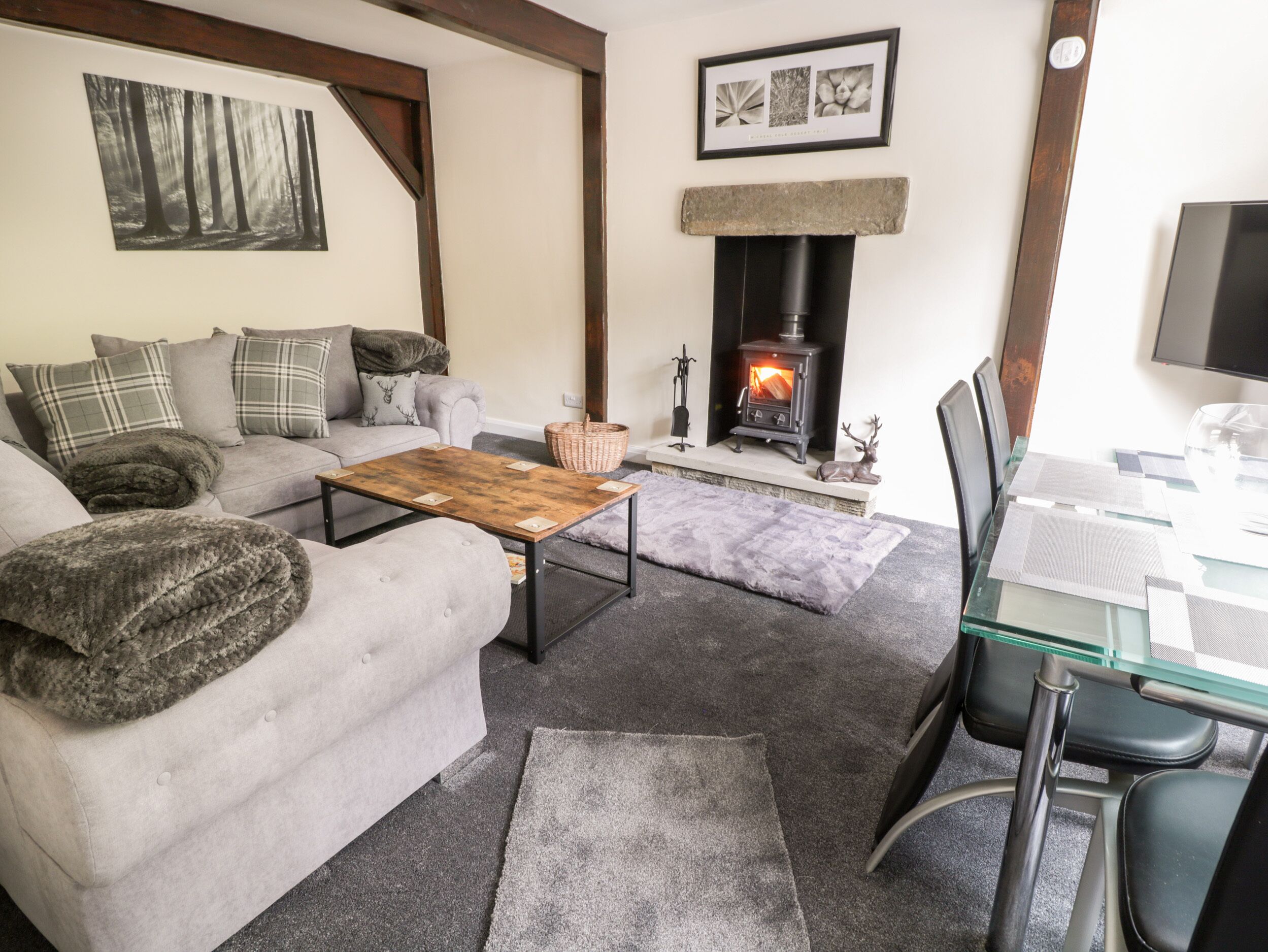 A cozy living room with a fireplace, a sofa, a coffee table, and a dining area with chairs.