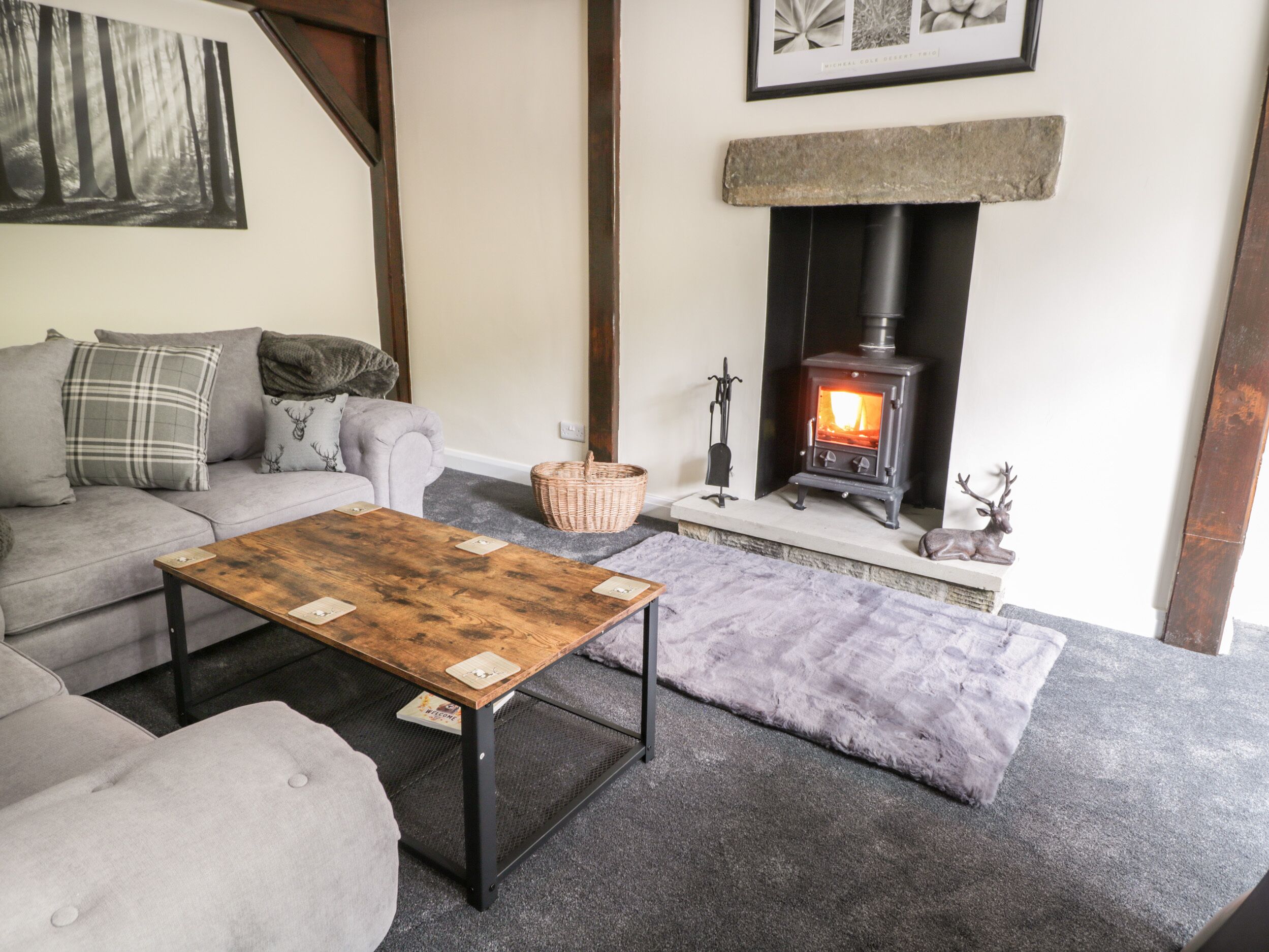 A cozy living room with a fireplace, a sofa, a coffee table, and a rug.