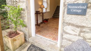A stone cottage entrance with a sign reading "Westmorland Cottage." - Westmorland Cottage (Grange-over-Sands)