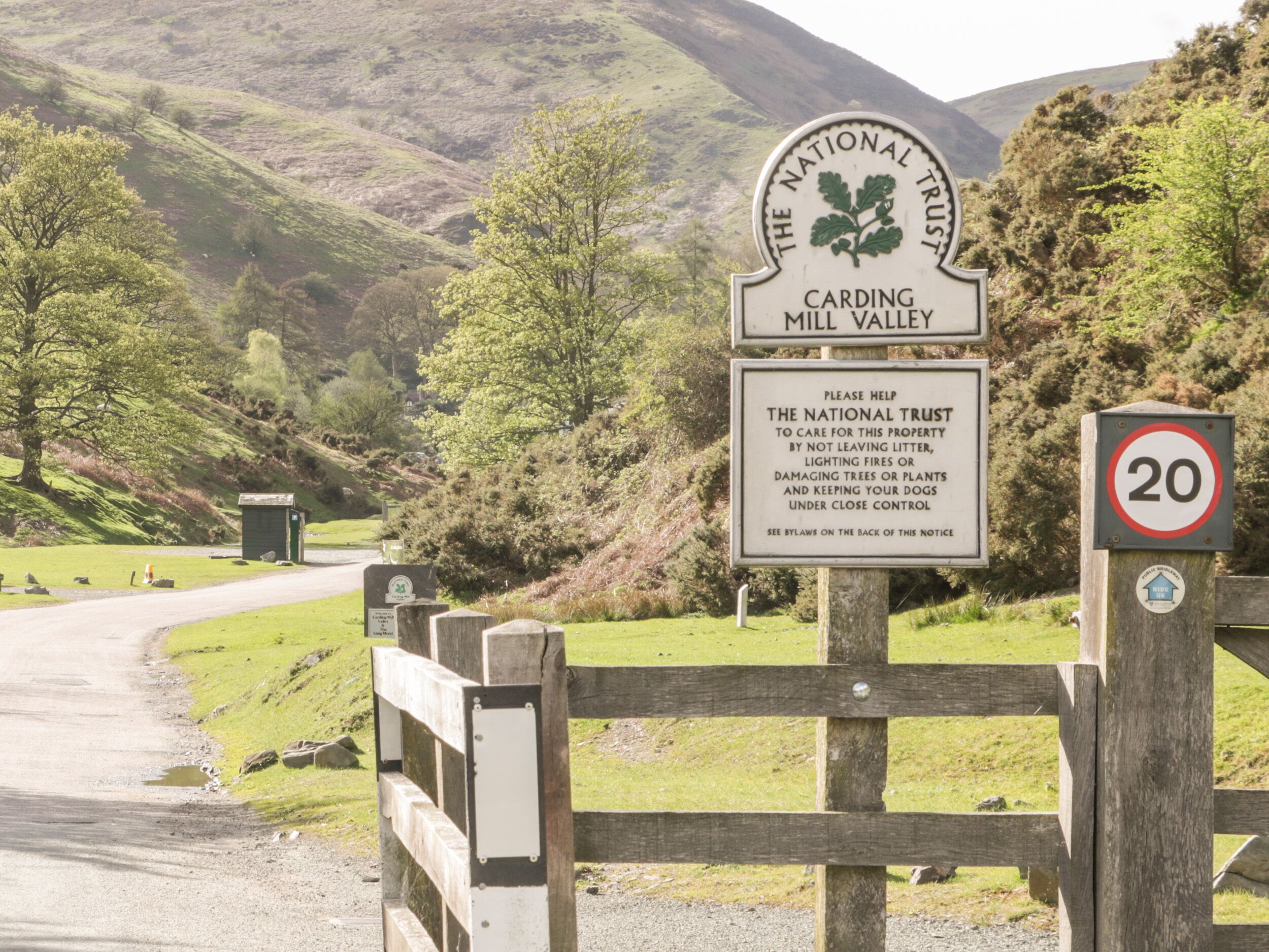 Cartel de The National Trust en Carding Mill Valley con una señal de límite de velocidad de 20.