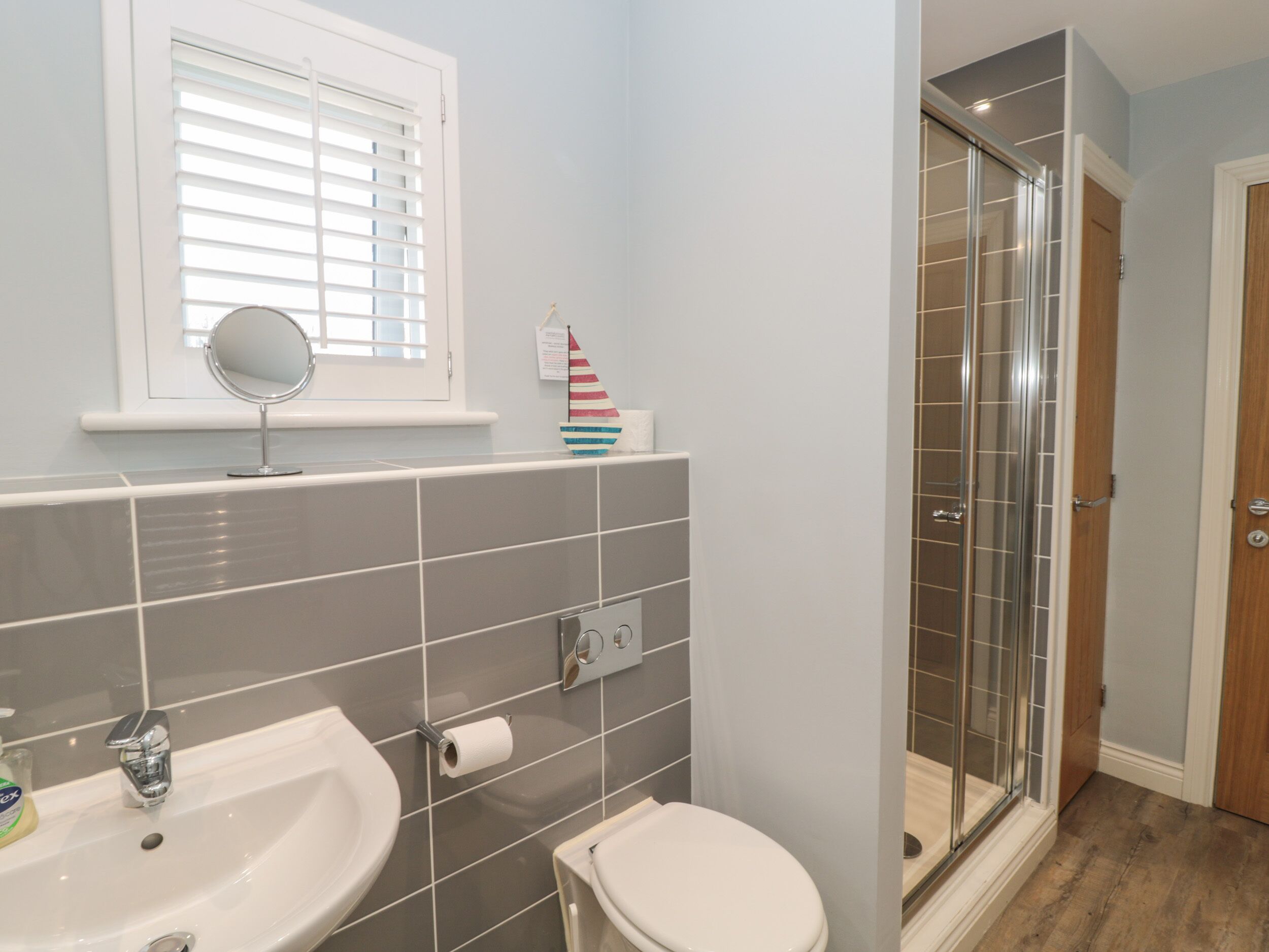 A bathroom with a sink, toilet, and a glass shower enclosure.