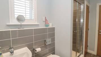 A bathroom with a sink, toilet, and a glass shower enclosure.