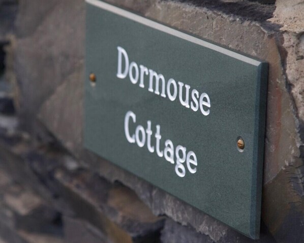 A sign for Dormouse Cottage.
