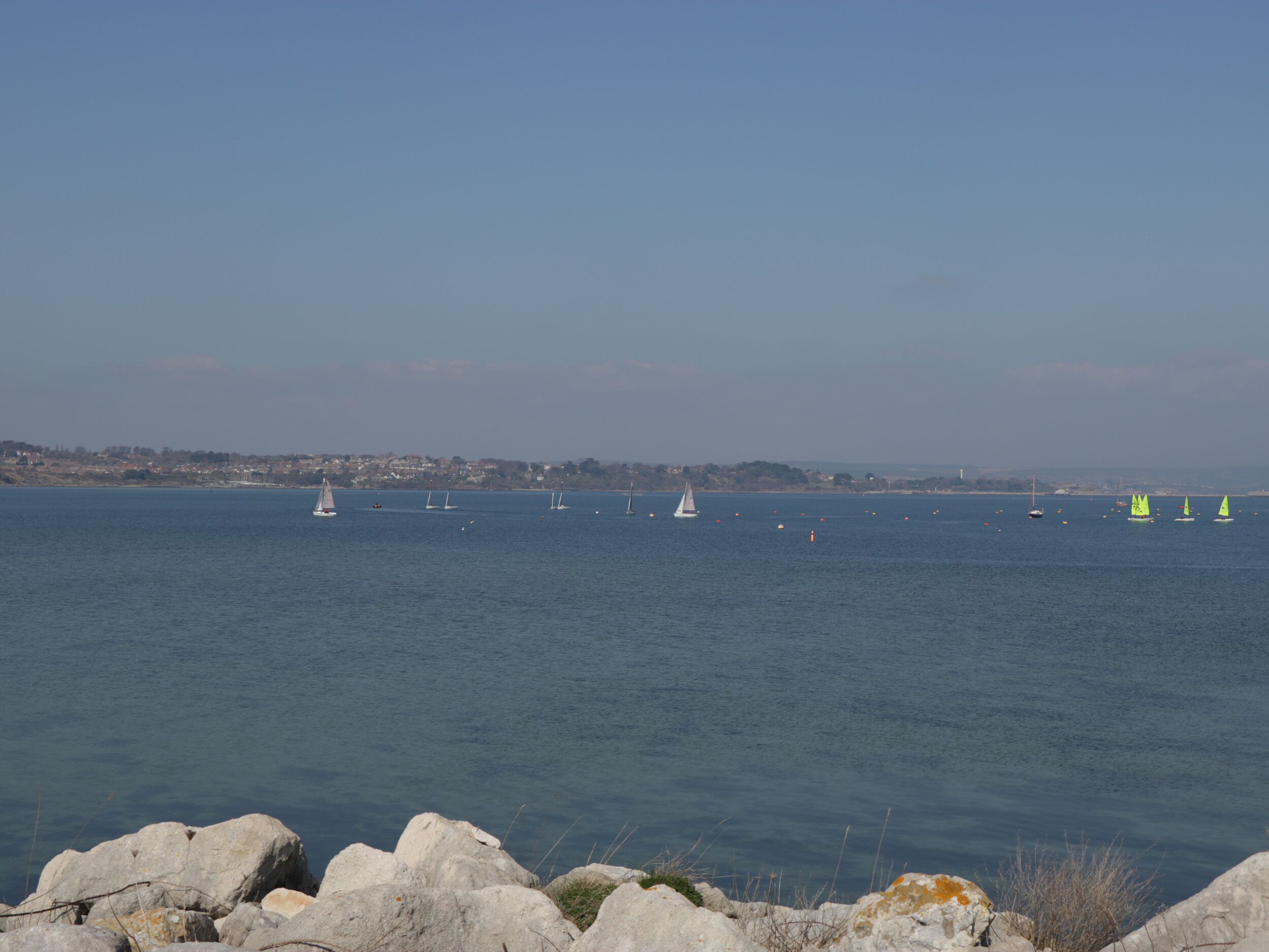 Blick auf die Küste mit felsigem Ufer und ruhiger See.