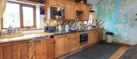 A kitchen with wooden cabinets, a microwave, a toaster, and a sink.