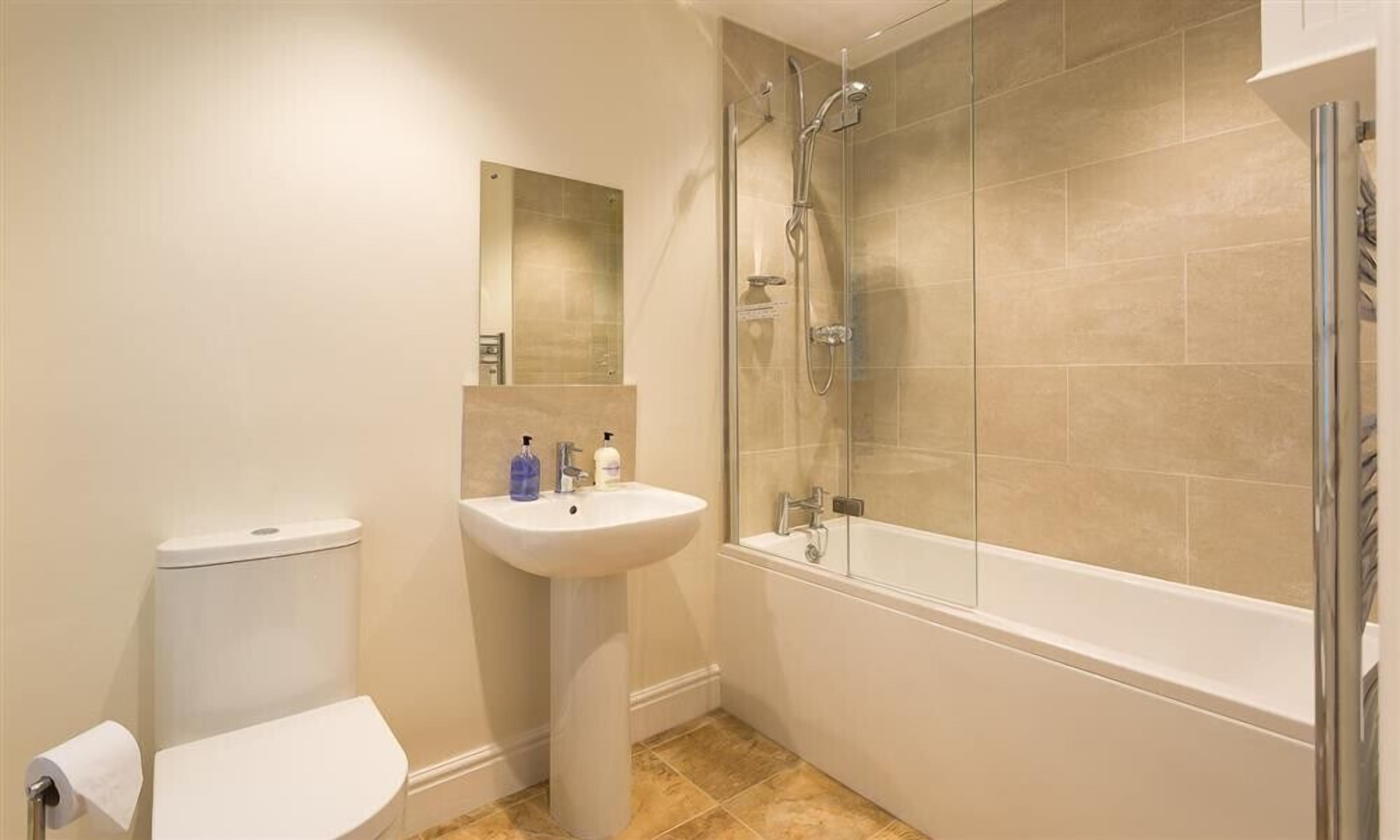 A bathroom with a toilet, sink, and bathtub.