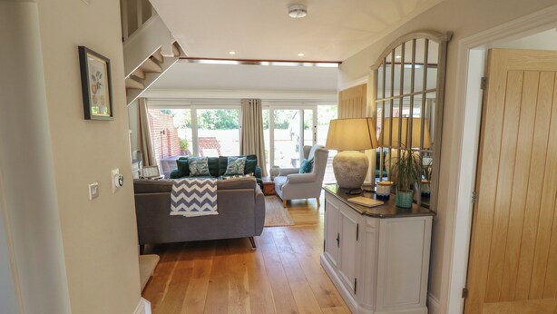 A spacious living area with a sofa, a lamp, and a cabinet.
