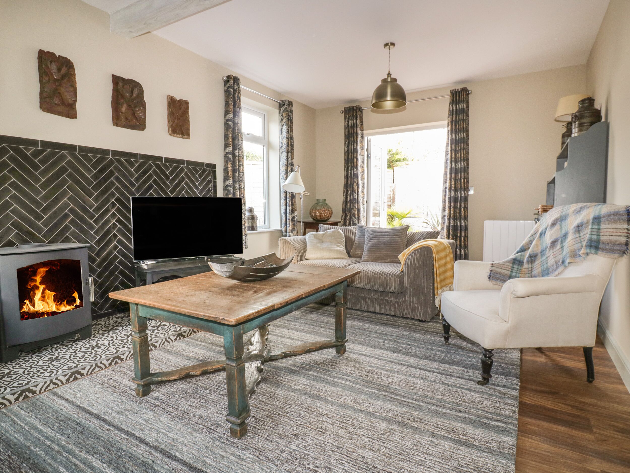 A cozy living room with a fireplace, a sofa, a coffee table, and a television.