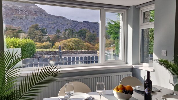 Una mesa de comedor con vistas a un paisaje montañoso a través de amplias ventanas.