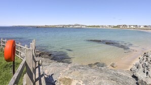 A coastal view with clear waters, a wooden walkway, and a sandy beach. - Bryngwyn - Trearddur Bay (Holyhead)
