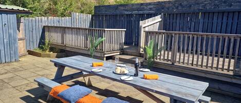 A wooden deck with a table set for two, surrounded by a wooden fence.
