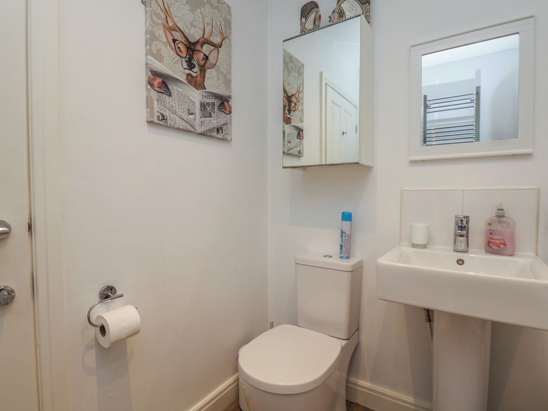 A bathroom with a toilet, sink, and a mirror.