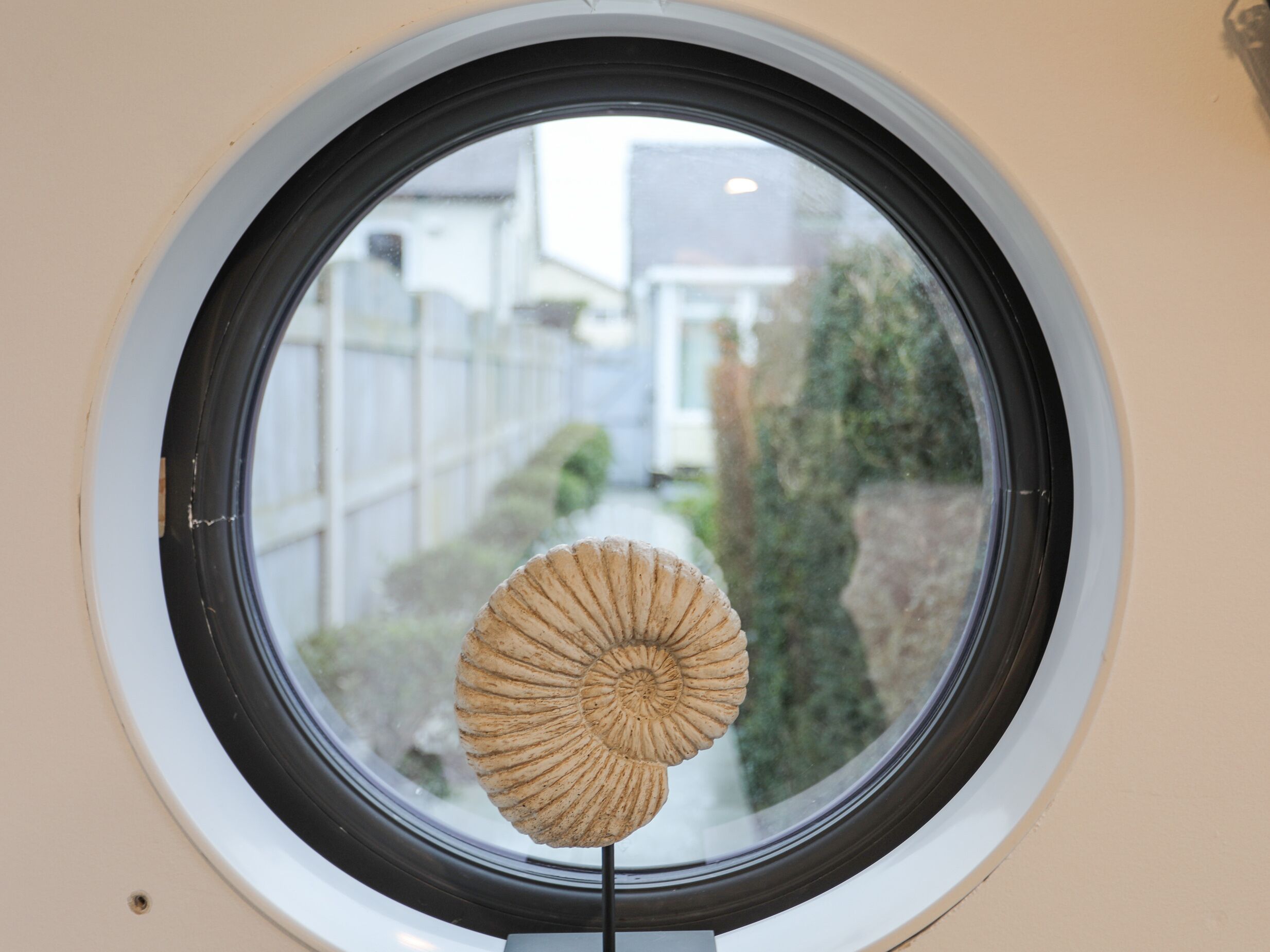 Une fenêtre ronde avec un fossile au centre.