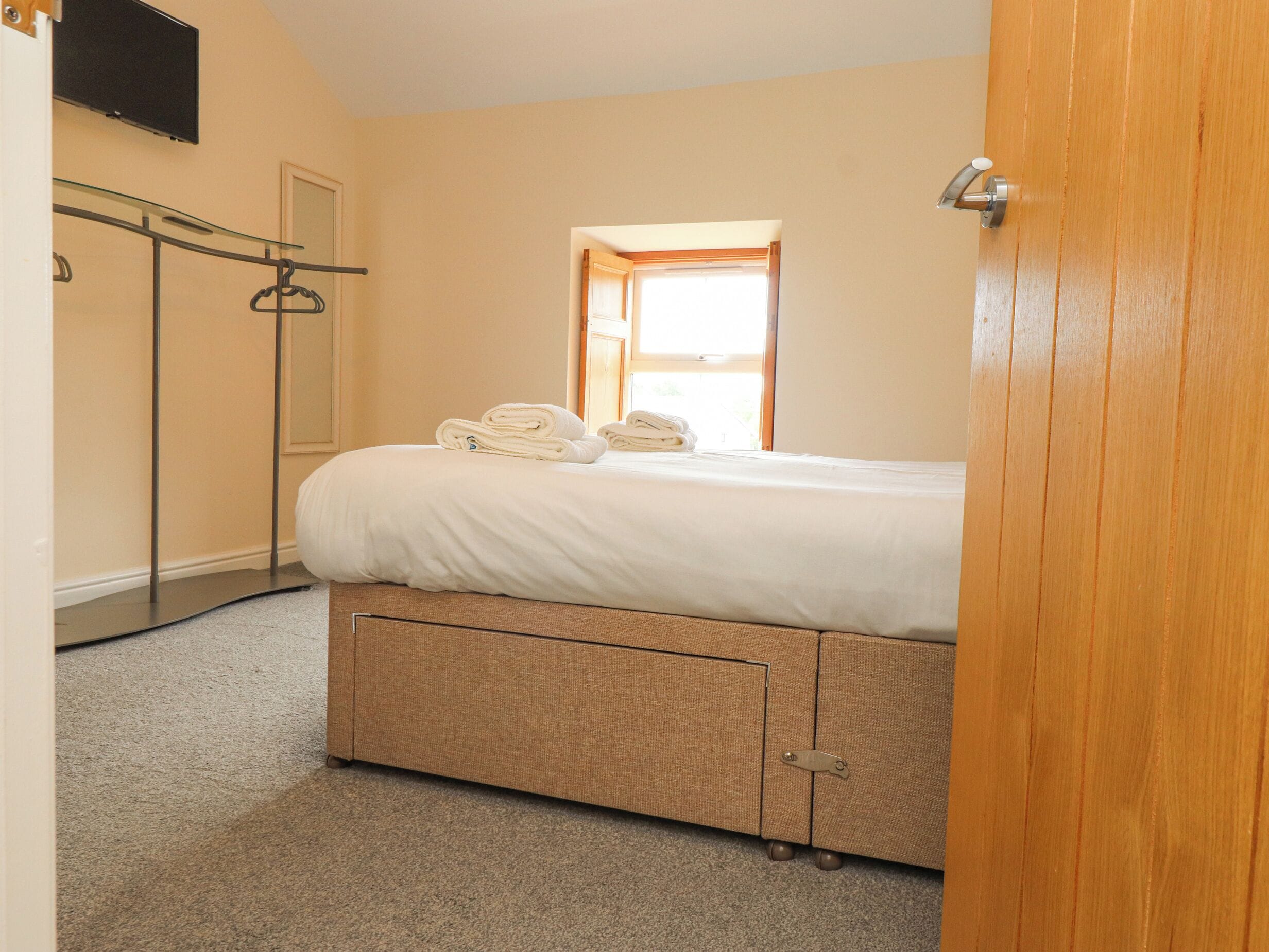 Un dormitorio con cama, armario, closet y ventana.
