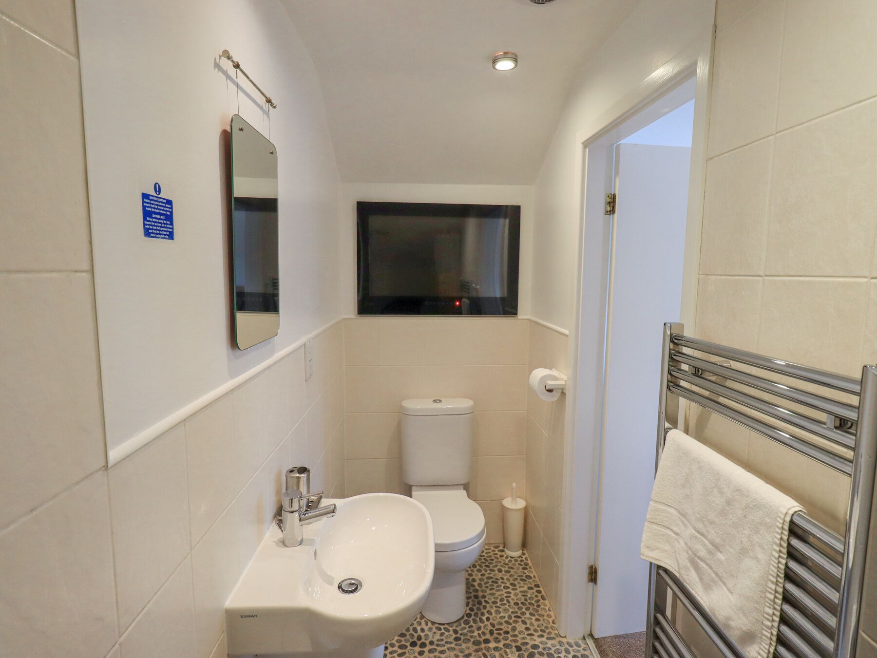 Un baño pequeño con inodoro, lavamanos y espejo.