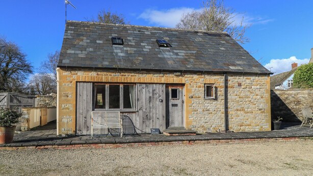 Un petit bâtiment en pierre, doté d’un toit en pente, d’une porte en bois et d’une petite fenêtre.