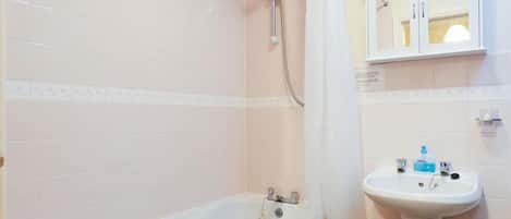 A bathroom with a bathtub, a shower, and a sink.