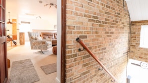 A room with a brick wall, a wooden door, and a metal railing. - Fairfield Cottage (Lincoln)