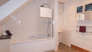 A modern bathroom with a glass-enclosed shower, a white bathtub, a sink, and a mirror above the sink. - Kinnaird House (Grantown-on-Spey)