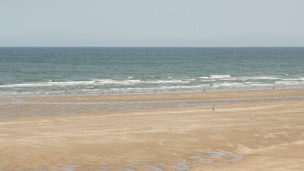 A wide sandy beach with gentle waves and a clear sky. - Hardy Cottage (Tyn-y-Gongl)