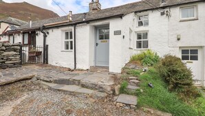 Un bâtiment blanc avec un escalier en pierre menant à une porte sur laquelle on peut lire « BLEASE GORTH ».