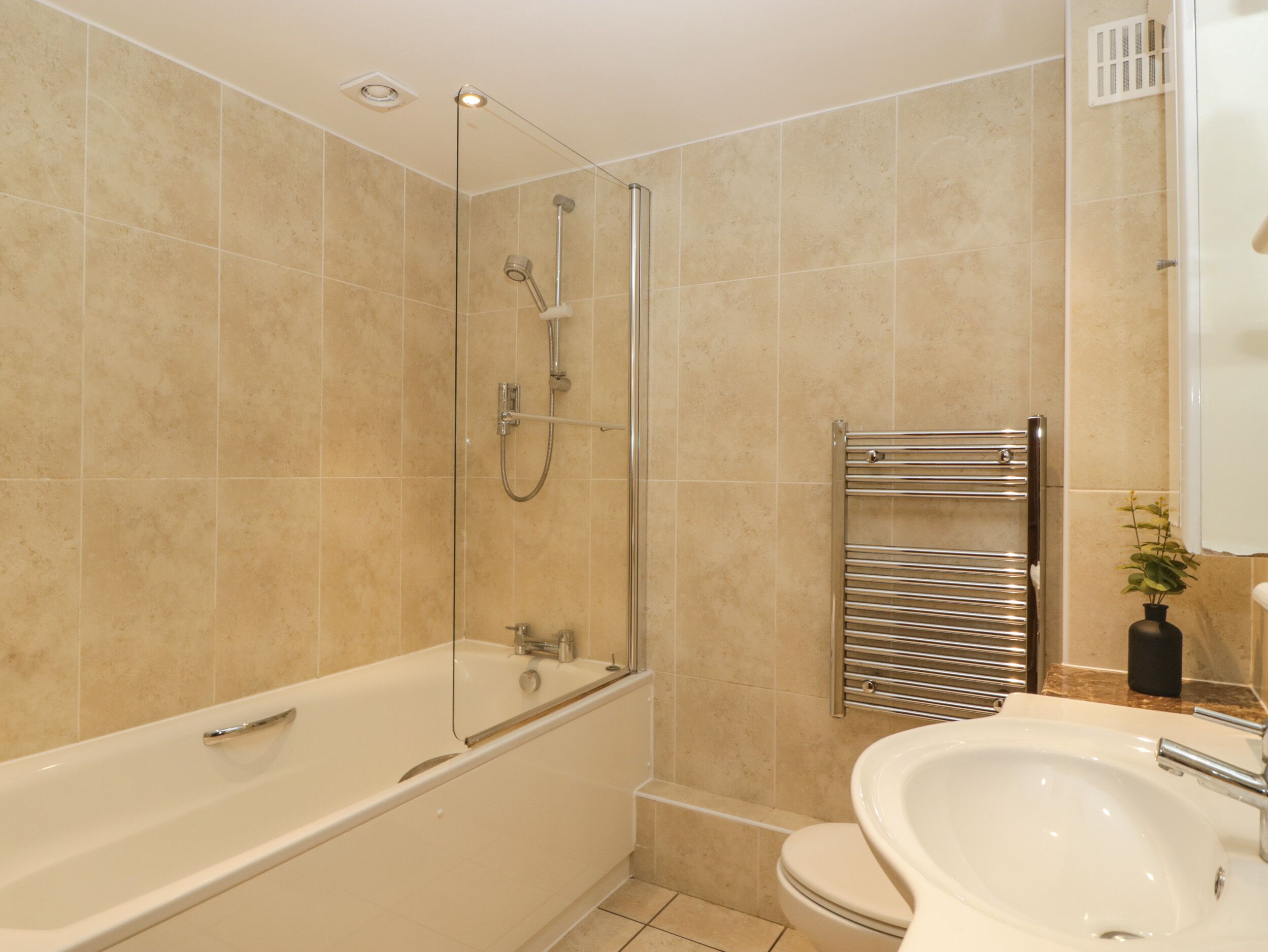 Un baño moderno con bañera, ducha y lavamanos.