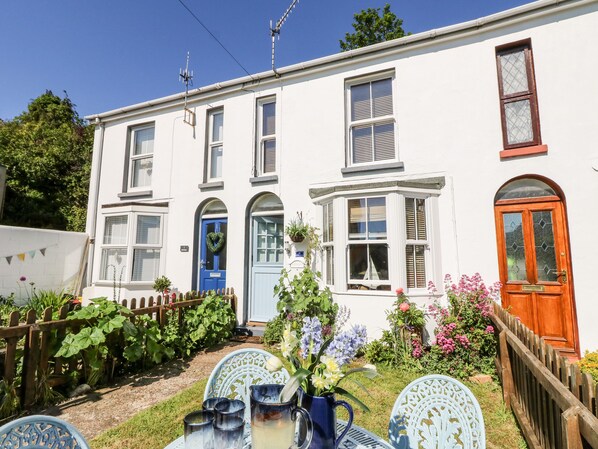 A white two-story house with a blue door, a bay window, and a wooden front door. - 2 Linden Terrace (Sandown)
