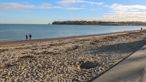 A beach with a sandy shore and a calm sea. - 2 Linden Terrace (Sandown)