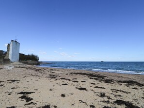 A beach with a white structure, possibly a monument, and a clear blue sky. - 2 Linden Terrace (Sandown)