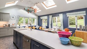Une cuisine moderne dotée de fenêtres de toit, d’un coin repas et offrant une vue sur le jardin.