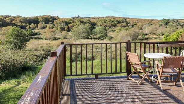 A wooden deck with a view of a hilly landscape. - Crolly Home (Crolly)