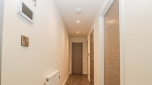 A narrow hallway with wooden flooring, white walls, and a white radiator. - Flat 2, 38 Preston Road (Weymouth)