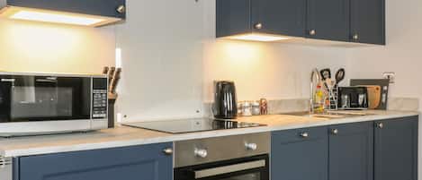 A modern kitchen with a built-in microwave, oven, and coffee maker.