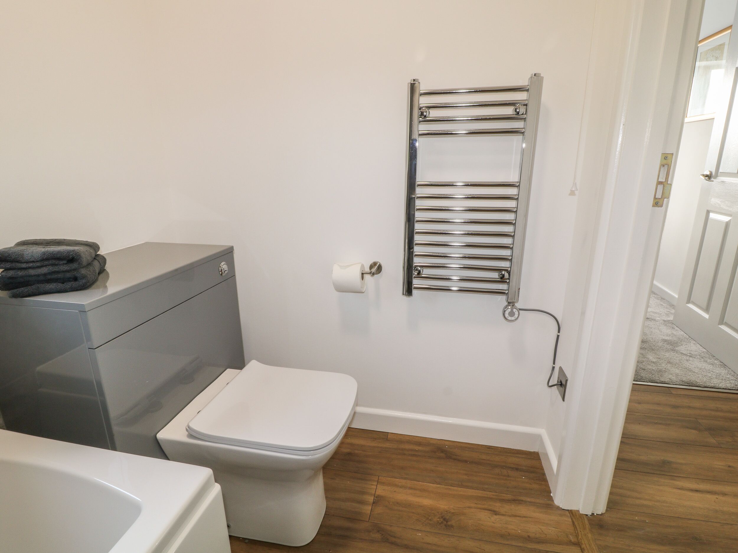 Une salle de bain comprenant des toilettes, une pile de serviettes et un porte-serviettes.