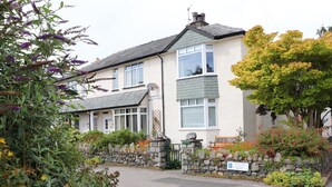 A two-story house with a stone wall and a driveway. - Fell View (Keswick)