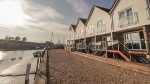 A waterfront property with multiple buildings, a dock, and a gravel path.